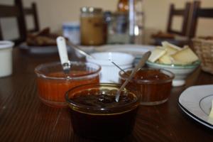 a wooden table with three jars of jam and food at La Maison de Joséphine in Risoul +17 photos