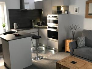 eine Küche und ein Wohnzimmer mit einem Sofa und einem Tisch in der Unterkunft The Luxury Apartment in Buxton