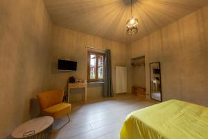 ein Schlafzimmer mit einem Bett, einem Tisch und einem Stuhl in der Unterkunft La Pitta in Gattinara