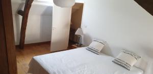 a bedroom with a white bed with two pillows at Maison Carol in Saumur
