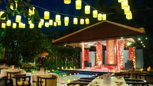 a restaurant with a swimming pool with tables and lights at Borei Angkor Resort & Spa in Siem Reap