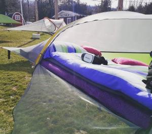tratwa leżąca na trawie obok namiotu w obiekcie Fińska Wioska Kalevala w mieście Borowice