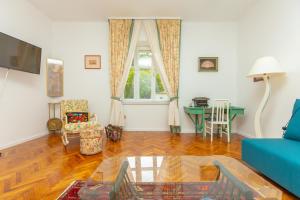 ein Wohnzimmer mit einem blauen Sofa und einem Tisch in der Unterkunft Apartment Villa Ahava in Dubrovnik