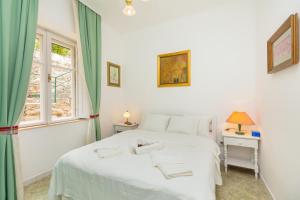 sypialnia z białym łóżkiem i oknem w obiekcie Apartment Villa Ahava w Dubrowniku