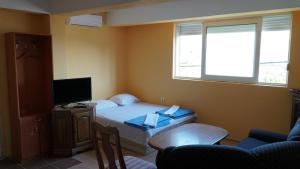 a small bedroom with a bed and a television at M2 Apartmani in Trebinje