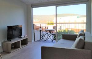 Il comprend un salon doté d'un canapé et d'une télévision à écran plat. dans l'établissement Anjo33 Flats, à Braga