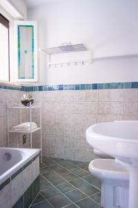 a bathroom with a sink and a tub and a toilet at Appartamento DAISY in Bardolino