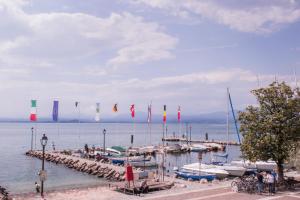 a group of boats docked at a dock with flags at Appartamento DAISY in Bardolino
