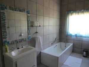 La salle de bains est pourvue d'une baignoire, d'un lavabo et d'une baignoire. dans l'établissement Spes Bona guesthouse, à Colesberg
