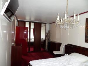 een slaapkamer met een bed en een kroonluchter bij Rot-Weiss in Bad Zwischenahn
