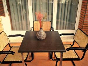 a black table with a vase on top of it at Pension Anoeta in San Sebastián