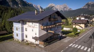 eine Luftansicht eines Gebäudes mit Bergen im Hintergrund in der Unterkunft Hotel Siera Hof in Sappada