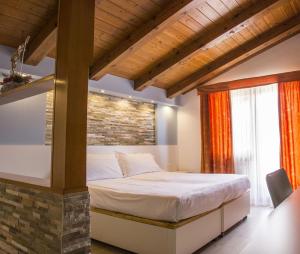 una camera con letto e muro di mattoni di Hotel Villaggio Nevada a Folgaria