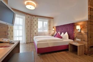 um quarto de hotel com uma cama grande e uma escrivaninha em Hotel Tiroler Stuben em Wörgl