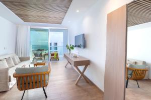 a living room with a desk and a couch at Limanaki Beach Hotel & Suites in Ayia Napa
