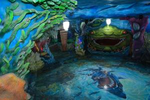 uma pintura de uma caverna com um monstro na água em Crazy House em Da Lat