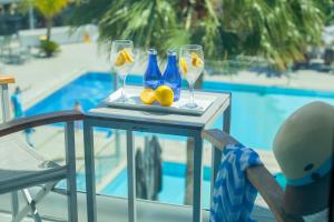 a table with glasses and lemons on it next to a pool at Limanaki Beach Hotel & Suites in Ayia Napa