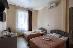 ein Hotelzimmer mit 2 Betten und einem Fenster in der Unterkunft Arnautskiy Hotel in Odessa