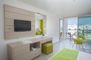 a living room with a tv on a wall at Limanaki Beach Hotel & Suites in Ayia Napa