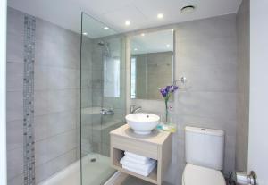 a bathroom with a sink and a toilet and a shower at Limanaki Beach Hotel & Suites in Ayia Napa