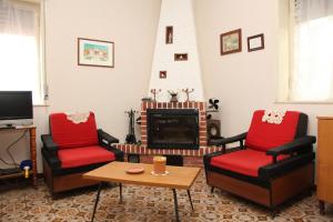 a living room with two chairs and a fireplace at CASA VACANZE FRANCESCO E TANINA in Nicolosi
