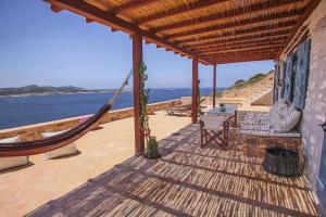 a porch with a hammock and a view of the ocean at Antiparos Vibes in Agios Georgios