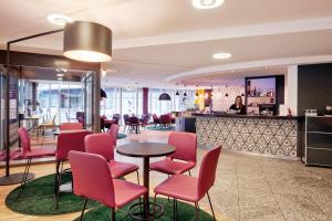 a restaurant with pink chairs and a table at Sorell Business Hotel Ador Bern in Bern