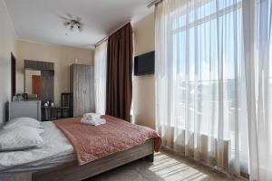 1 dormitorio con cama y ventana grande en Arnautskiy Hotel, en Odessa