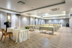 una sala per banchetti con tavoli e sedie bianchi di Beehive Boutique Hotel Phuket a Phuket Altre 41 foto
