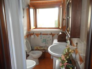La petite salle de bains est pourvue de toilettes et d'un lavabo. dans l'établissement La Pineta di Giove - Casa Lory, à Campo di Giove