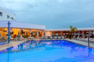 a large swimming pool with chairs and a hotel at Limanaki Beach Hotel & Suites in Ayia Napa