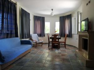 a living room with a couch and a table and chairs at Don Bazilio Seahouse in Leptokarya