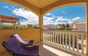 Un porche con dos sillas en un balcón. en Apartman Dora, en Povljana