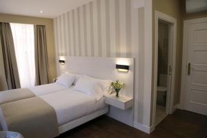 a bedroom with a white bed and a window at VÍA XIX in Caldas de Reis