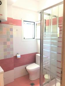 La salle de bains est pourvue de toilettes et d'une fenêtre. dans l'établissement House with a garden in the Lakithra, à Lakíthra