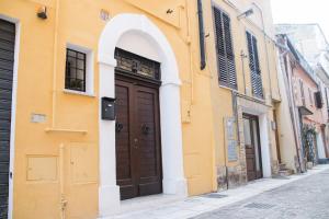 a yellow building with a brown door on a street at B&B Teate in Chieti
