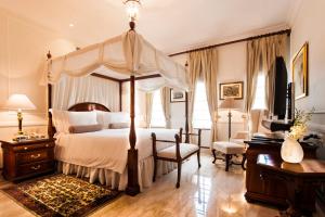 a bedroom with a canopy bed and a desk at The Imperial, New Delhi in New Delhi