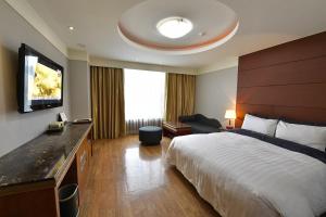 a hotel room with a bed and a flat screen tv at Lake Tourist Hotel in Seoul