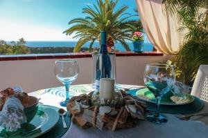 a table with two wine glasses and a table with a view at Apt El Perenquen in Santa Cruz de Tenerife