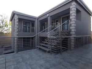 ein Haus mit einer Treppe auf einer Terrasse in der Unterkunft Lucolo Palace B&B - Mthatha in Mthatha