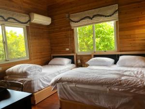 Postel nebo postele na pokoji v ubytování Yiyue Guanhe Homestay 倚月觀荷民宿