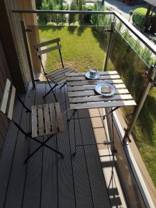 Una mesa de madera y una silla en un porche. en Lavender Home ground floor, en Juodkrantė
