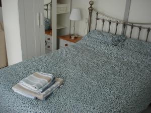 a bed with two towels sitting on top of it at HOLLYDENE LODGE in Whitstable