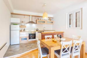 a kitchen with a wooden table and white appliances at Apartment Mikula in Makarska