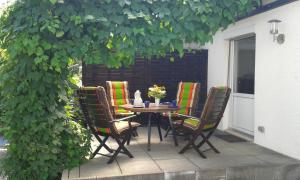 une table et des chaises sur une terrasse sous un arbre dans l'établissement Ferienwohnung Holterhoff, à Olpe