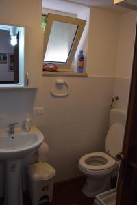 スフェッラカヴァッロにあるSferracavallo Apartmentsのバスルーム(トイレ、洗面台付)、窓が備わります。