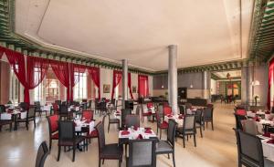 a dining room with tables and chairs and red curtains at Mogador Kasbah in Marrakesh