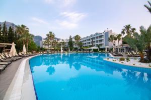 a swimming pool at a resort with blue water at Fame Residence Goynuk in Kemer