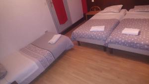 um quarto com 3 camas e um piso de madeira em Hotel de Savoie em Annecy