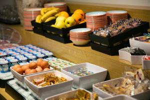 a buffet of food with eggs and fruit in boxes at Hôtel Vert in Le Mont Saint Michel